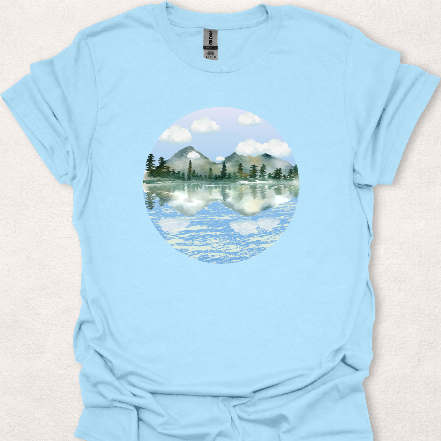 Light Blue t-shirt featuring the Stillwater watercolor mountain lake reflection design.